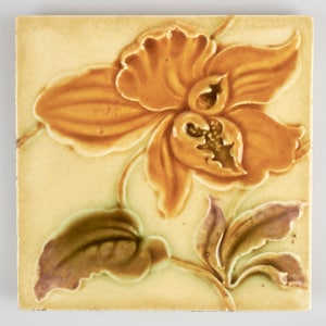 Peut inclure: Carreau de céramique carré avec un motif en relief d'une fleur d'orchidée orange et de feuilles vertes et violettes. Le carreau a un fond jaune clair avec une texture craquelée, d'aspect vintage. Mesure environ 15 cm x 15 cm.