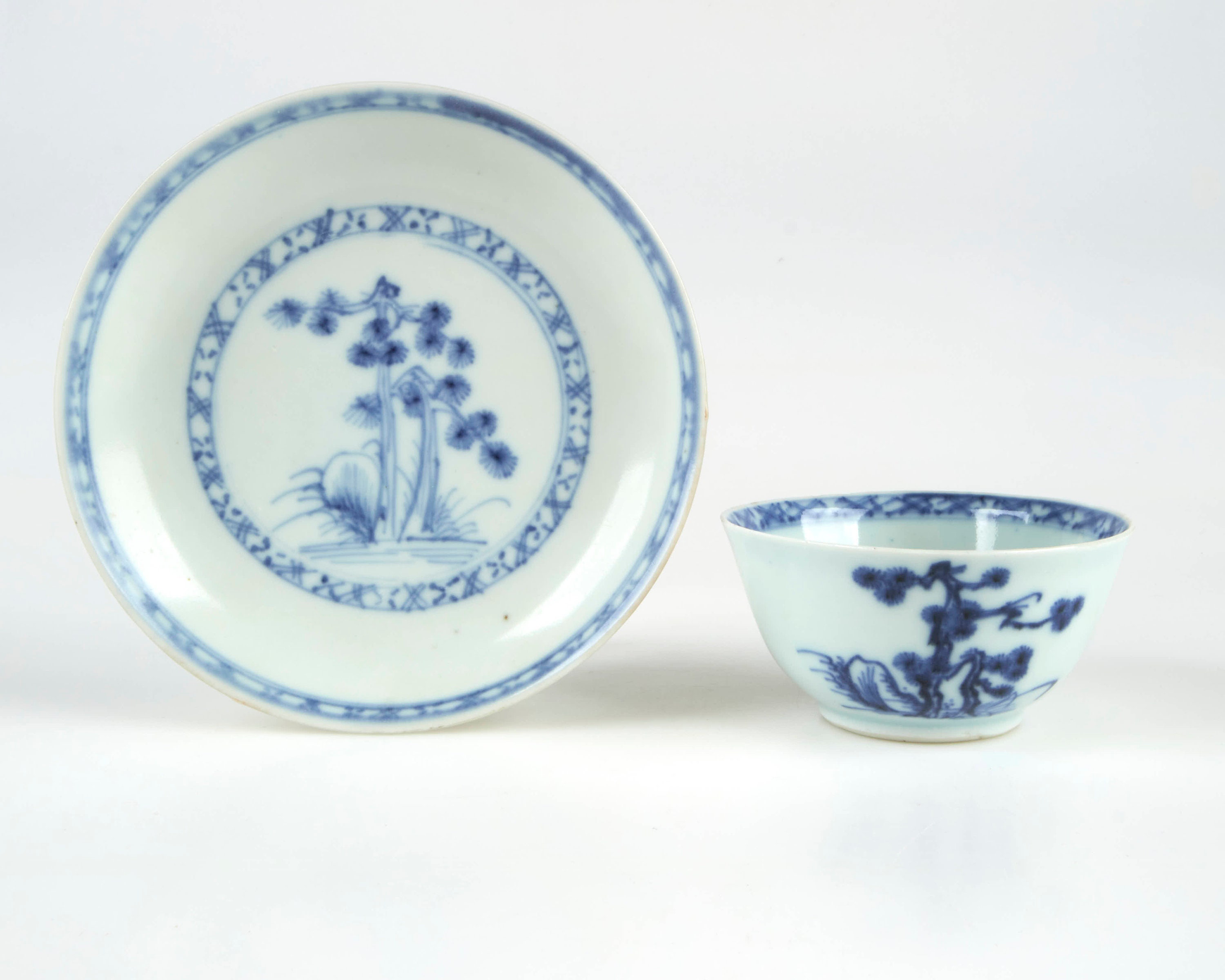Antique 18th century Chinese blue and white Nanking Cargo “Pine Tree” pattern tea bowl and saucer. Crack to tea bowl.
