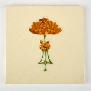 May include: Square ceramic tile with a stylized orange flower and green detailing. The flower is centrally positioned on a cream-coloured background. The tile has a vintage aesthetic, with a slightly aged appearance.