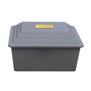 May include: A gray cremation urn with a gold plaque that reads "Ralph Everett Jackson 1937 - 2023 Beloved Husband and Father".