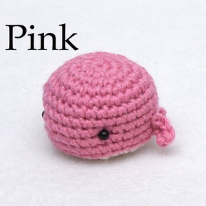 May include: Pink crocheted whale amigurumi toy with black eyes.