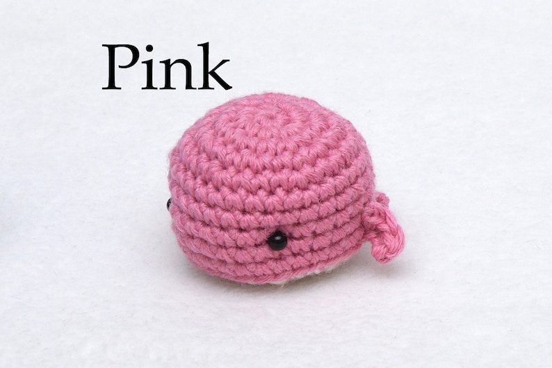 May include: Pink crocheted whale amigurumi toy with black eyes.