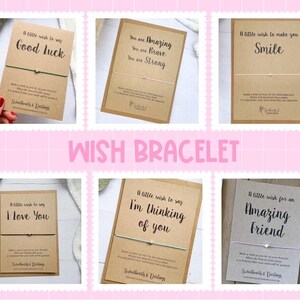 May include: A collection of wish bracelets on kraft paper cards with various messages like "Good Luck" and "I Love You." Each card has a small charm and a string bracelet. The word "WISH BRACELET" is displayed in pink.