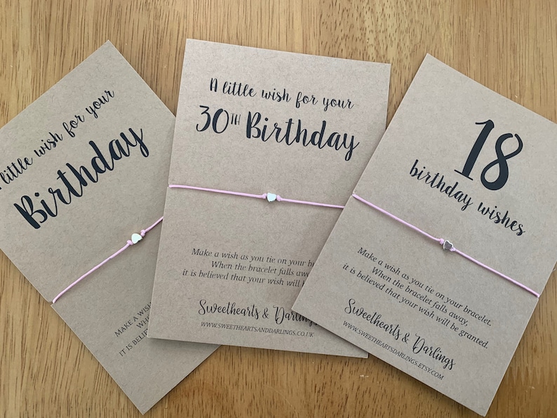 K&ouml;nnte beinhalten: Drei braune Karten mit rosafarbenen Schnurarmb&auml;ndern. Die Karten haben den Text "A little wish for your 30th Birthday", "A little wish for your Birthday" und "18 birthday wishes".