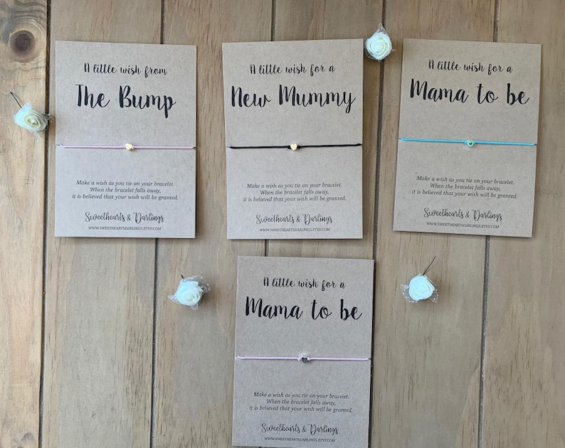 May include: Four greeting cards with bracelets, each with a different message: "A little wish from The Bump", "A little wish for a New Mummy", and "A little wish for a Mama to be". Each card has a bracelet with a small charm.