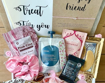 Può includere: Un cesto regalo a tema rosa e bianco. Include una maschera per il viso rosa, una bomba da bagno rosa e bianca, una candela rosa e bianca, una lima per unghie rosa e bianca, un elastico per capelli rosa e bianco, una tavoletta di cioccolato rosa e bianca, sale da bagno rosa e bianco, sapone rosa e bianco, una maschera per gli occhi rosa e bianca e un braccialetto rosa e bianco. Il cesto è pieno di carta velina rosa e bianca e ha un nastro rosa e bianco.