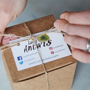Puede incluir: Una caja de cart&oacute;n marr&oacute;n atada con cuerda y una etiqueta de regalo. La etiqueta tiene el texto "Lucy Antwis" y los iconos de redes sociales para Facebook, Twitter, Instagram y Pinterest. El texto "LucyAntwisCrafts" y "www.lucyantwis.com" tambi&eacute;n est&aacute;n en la etiqueta.