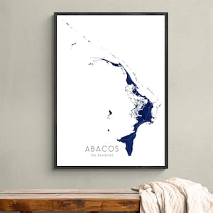 May include: A black framed print of a map of the Abacos, The Bahamas, in blue on a white background. The text "ABACOS THE BAHAMAS" is printed below the map.
