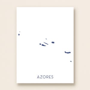 May include: A minimalist print featuring a map of the Azores islands in a deep blue hue against a white background. The word "AZORES" is printed in a simple, dark blue font at the bottom of the print.