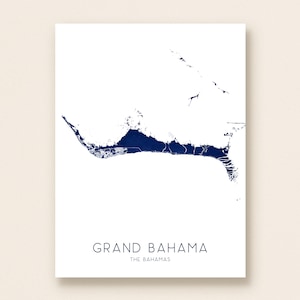 May include: A minimalist art print featuring a navy blue map of Grand Bahama, The Bahamas, on a white background. The text "GRAND BAHAMA" and "THE BAHAMAS" are printed in a dark blue font below the map. This print is suitable for home decor.