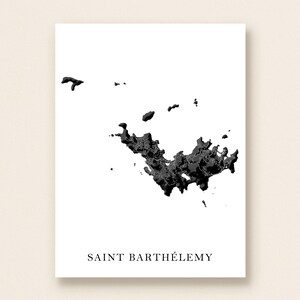 May include: A black and white print of Saint Barthélemy, a Caribbean island. The island's shape is depicted in a detailed, textured black design against a white background. The text "SAINT BARTHÉLEMY" is printed in a simple font at the bottom.