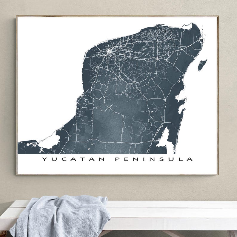 May include: A framed print featuring a map of the Yucatan Peninsula in a dark teal color. The map shows roads and cities in white against the teal background. The words "YUCATAN PENINSULA" are printed in black at the bottom.