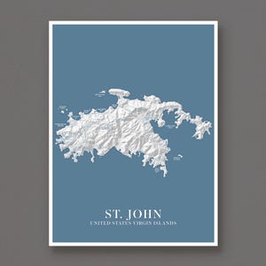 May include: A vertical wall art print featuring a white 3D-style topographic map of St. John, United States Virgin Islands, set against a solid blue background. The map includes labeled bays and beaches, with the text ST. JOHN UNITED STATES VIRGIN ISLANDS printed in white at the bottom.