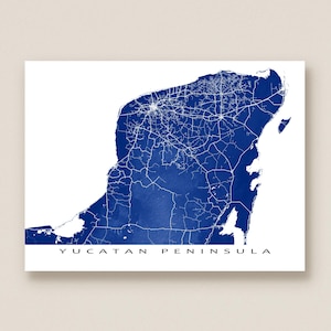 May include: A blue and white map print of the Yucatan Peninsula. The map features a detailed depiction of roads and infrastructure in white against a blue background. The words "YUCATAN PENINSULA" are printed in black at the bottom.