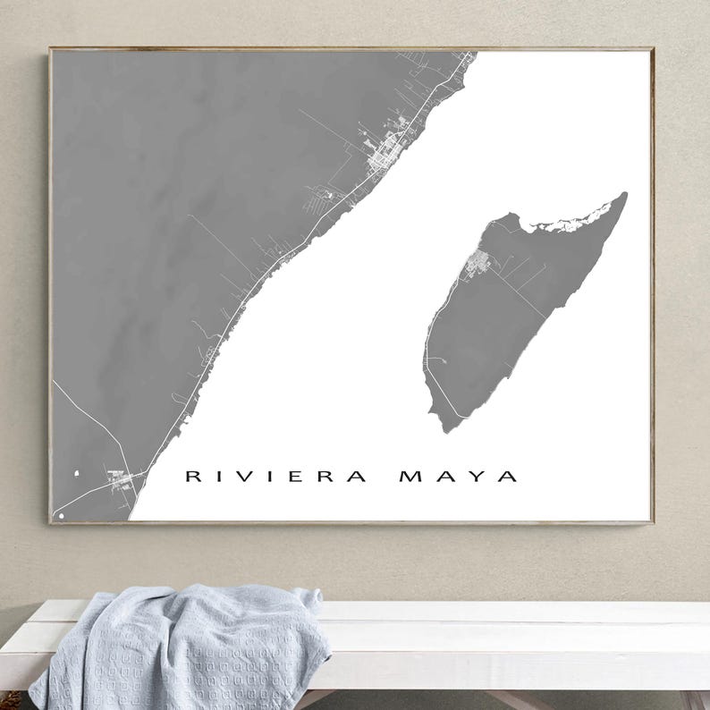 May include: A framed print featuring a grayscale map of the Riviera Maya coastline. The map highlights the geographical features with varying shades of gray against a white background. The words "RIVIERA MAYA" are printed in black.