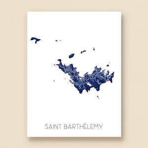 May include: A white print featuring a detailed navy blue map of Saint Barthélemy. The island's outline is filled with intricate details, and the name "SAINT BARTHÉLEMY" is printed in a simple font below the map. The print is on a white background.