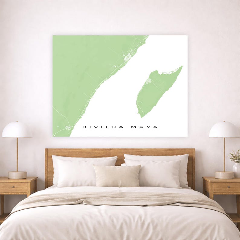 May include: A framed wall art print featuring a map of Riviera Maya in a light green hue against a white background. The text "RIVIERA MAYA" is printed in black. The artwork is displayed above a bed with wooden nightstands and lamps.