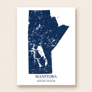 Peut inclure: Une impression cartographique verticale du Manitoba en bleu marine foncé sur fond blanc. La carte présente des plans d'eau blancs, dont le lac Winnipeg, et des lieux indiqués comme Churchill, Thompson, Brandon et Winnipeg. Le texte indique MANITOBA.