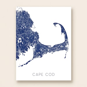 May include: A minimalist print featuring a detailed map of Cape Cod in navy blue against a white background. The map highlights the roads and geographical features of the area. The words "CAPE COD" are printed in a simple font below the map.