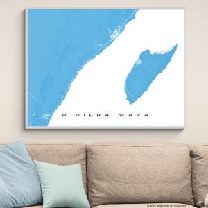 May include: A framed map print of Riviera Maya, featuring a light blue coastal area against a white background. The text "RIVIERA MAYA" is centered at the bottom in a black, sans-serif font. The print is in a white frame.