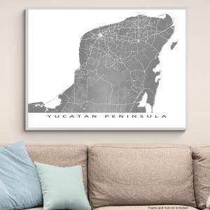 May include: A framed grayscale map print of the Yucatan Peninsula. The map features detailed road networks and geographical features. The text "YUCATAN PENINSULA" is printed in a clean, sans-serif font at the bottom of the print.