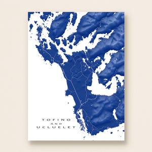 May include: A blue and white topographical map print of Tofino and Ucluelet. The map features a 3D effect, with the land areas in shades of blue and the water areas in white. The text "Tofino and Ucluelet" is printed in black at the bottom.