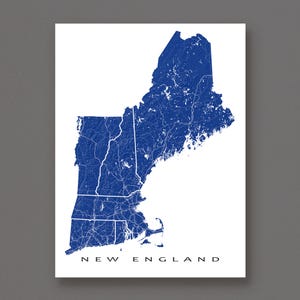 以下が含まれることがあります： 「NEW ENGLAND」の文字が下部に書かれた、青と白のニューイングランドの地図。地図には州の輪郭と内部の道路や水路が示されています。地図は白い背景に印刷されています。