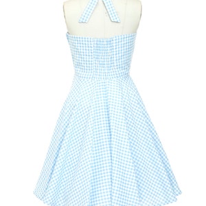 K&ouml;nnte beinhalten: Hellblau-wei&szlig;es Gingham-Halterkleid auf einer Schaufensterpuppe. Das Kleid hat ein figurbetontes Oberteil, einen ausgestellten Rock und eine passende Schleife am Halter-Ausschnitt. Ein klassischer Stil, perfekt f&uuml;r einen Sommertag.