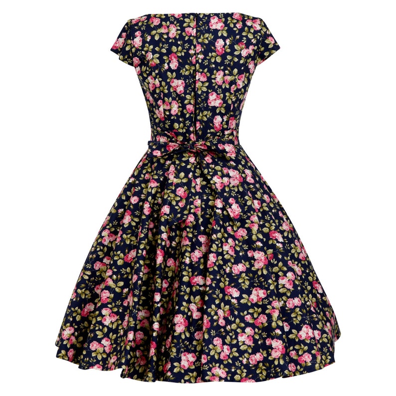 K&ouml;nnte beinhalten: Ein dunkelblaues Kleid mit einem durchgehenden Muster aus kleinen rosa Rosen und gr&uuml;nen Bl&auml;ttern. Das Kleid hat kurze &Auml;rmel, ein eng anliegendes Oberteil, einen weit schwingenden Faltenrock und ein Stoffband in der Taille. Ein Rei&szlig;verschluss ist sichtbar.