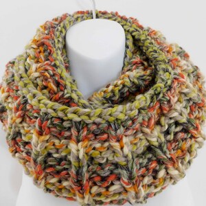 May include: A chunky knit infinity scarf in a mix of green, orange, beige, and gray yarn.