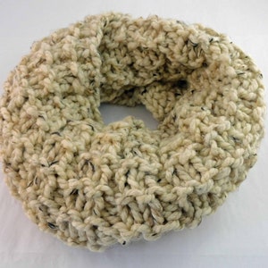 May include: A chunky knit cream-colored infinity scarf with black flecks throughout.