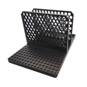 May include: A black desk organiser with a honeycomb pattern on the upright sections and a studded base. The organiser is made of a matte black material and is designed to hold items upright.