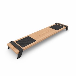 Pode incluir: Um suporte de monitor de madeira com acabamento castanho claro e duas almofadas de borracha pretas. O suporte tem suportes de metal preto e foi projetado para elevar um monitor de computador. O suporte tem cerca de 76 cm de comprimento.