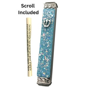 May include: A silver mezuzah case with a blue and white glitter design. The case has a silver Star of David on the front. A scroll is included.