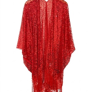 May include: A bright red open-front kimono featuring an all-over sequin embellishment on a sheer mesh fabric. This garment has wide, loose sleeves and a long fringe trim along the bottom hem, hanging from a wooden hanger against a plain background.