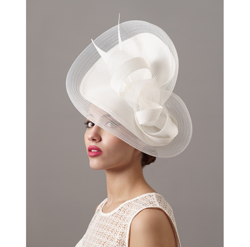Bride with her white wedding fascinator hat with veil -  Mujer con un sombrero de boda blancon con velo perfecto para novias mas modernas o invitadas que quieran complementar su look de boda -