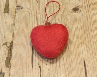 Adorno para árbol de Navidad hecho a mano con forma de corazón rojo de fieltro.