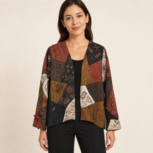 May include: A long-sleeved open-front jacket featuring a patchwork design with various geometric patterns and embroidered details in shades of brown, black, rust, and cream. The garment has a V-neckline and straight sleeves with folded cuffs.
