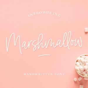 Peut inclure: Présentation de Marshmallow, une police d'écriture manuscrite affichée sur un fond rose avec des guimauves blanches éparpillées. La police est de style script avec une apparence délicate et fluide.