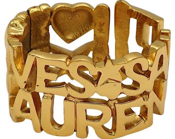 YVES SAINT LAURENT * Bracciale vintage in metallo dorato con lettere cuori e stelle