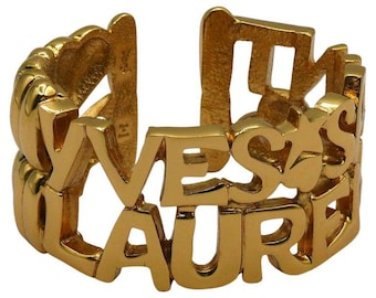 YVES SAINT LAURENT * Vintage guldfärgad metallmanschettarmband med bokstäver, hjärtan och stjärnor