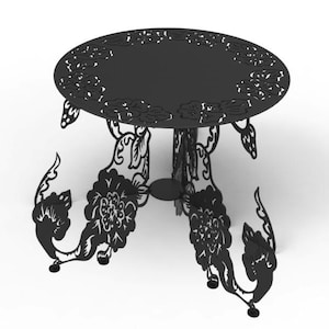 May include: Black metal side table with a round top and ornate floral cutouts. The table has three legs with decorative floral and leaf designs. The table is suitable for indoor or outdoor use.