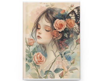 May include: A journal featuring a watercolor illustration of a woman with closed eyes, adorned with roses and a butterfly wing. The artwork has a soft, pastel color palette with pink, peach, and green hues. The journal's cover is a light beige.