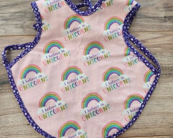 I Believe in Unicorns Bapron = Bib + Apron. It is a Full Coverage Tie On Bib that protects your Newborn, Baby or Toddler from big messes.