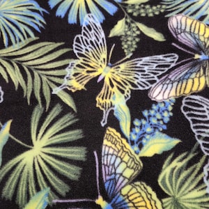 May include: A black fabric featuring a repeating pattern of butterflies and tropical palm leaves. The butterflies are rendered in shades of yellow, blue, and purple with white outlines, while the palm leaves appear in soft green and blue tones.