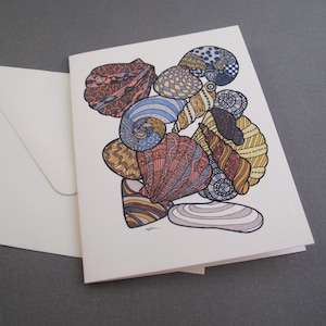 May include: A greeting card featuring a colorful illustration of seashells with intricate patterns in shades of blue, yellow, orange, and brown.