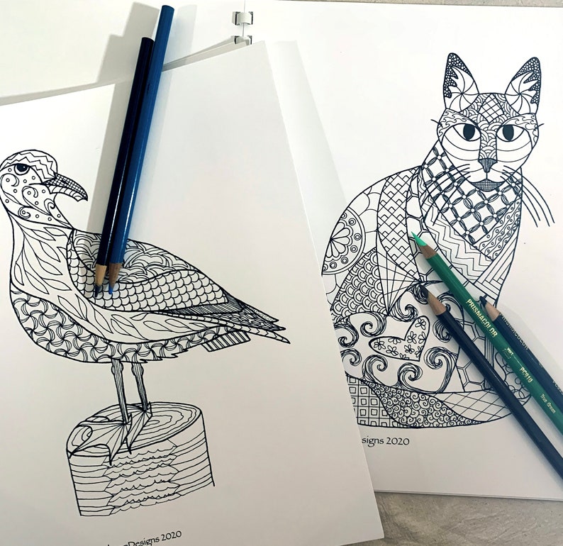 K&ouml;nnte beinhalten: Zwei Schwarzwei&szlig;-Malvorlagen, eine mit einer M&ouml;we, die auf einem Baumstamm sitzt, und die andere mit einer Katze. Beide Seiten haben komplizierte Designs und sind bereit zum Ausmalen.