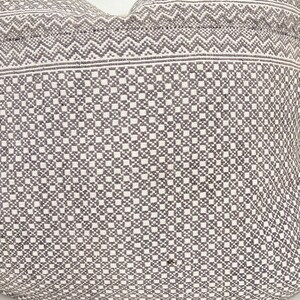 May include: A white pillow with a gray geometric pattern. The pattern is a combination of small squares and zigzags.