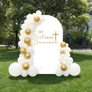 Pode incluir: Uma placa branca em forma de arco com o texto "MY First HOLY Communion" e uma cruz dourada. A placa é decorada com balões brancos e dourados e está colocada em um gramado.