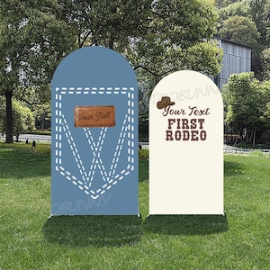 May include: Two decorative yard signs. One is blue with a denim pocket design and the text "Your Text" on a brown leather-like patch. The other is off-white with a cowboy hat graphic and the text "Your Text FIRST RODEO".